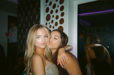 two beautiful young women hugging each other at a party