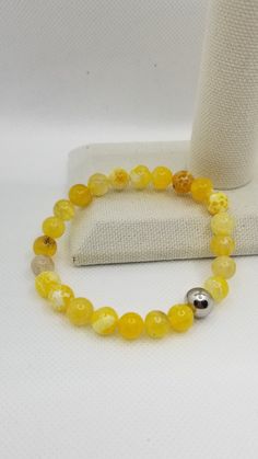 Meaning of the yellow agate stone:  This gem represents and signifies kindness, joy and optimism. Even the vast majority of times it is associated with wisdom, creativity and general knowledge, for this reason, it is thought to help balance the chakras that clear or clear the mind.  This bracelet has been elaborated with 8mm Yellow Agate cracked beads, with stretch elastic cord and a stainless steel bead with Coly's Touch logo.  Made to order in different sizes. Nice gift for any occasion.  CARE INSTRUCTIONS  To maintain the order quality of your new bracelet, please: - Roll bracelet On and Off, be sure to not overstretch the elastic cord.  - Avoid contact with water, perfumes and other chemicals.  - Remove when sleeping, exercising or doing other physically strenuous activities. - Store y Touch Logo, Pulseras Aesthetic, Yellow Agate, Multiple Bracelets, New Bracelet, Yellow Aesthetic, General Knowledge, Miami Fl, Agate Stone