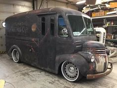 an old black truck parked in a garage