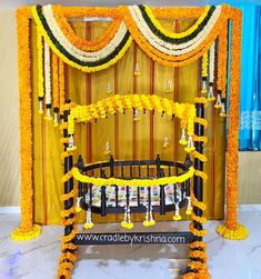 a decorated baby crib in front of a wall with yellow and white flowers on it