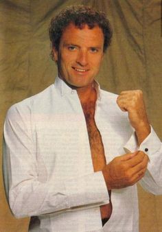 a man in white shirt and tie posing for the camera with his fist raised up