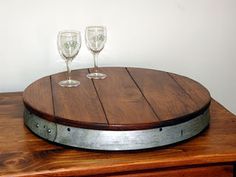 two wine glasses sitting on top of a wooden table next to an empty glass holder