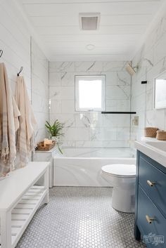 a bathroom with marble tile and white fixtures