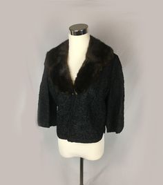 "A vintage rayon ribbon knit  jacket in black with a brown mink shawl collar. The knit is in florals and swirls with notched back hem and cuffs. The sleeves are 3/4. The jacket is fully lined and the fur collar is attached with snaps for removal and easy dry cleaning. It closes with a hidden hook and eye at the base of the collar. The label reads, \"Ribbon Knit Original by Dolly Muff Mfg. Co.\" The jacket measures 36\" around the bust, the shoulders are 14\" across, the sleeves are 15\" and the Vintage Outerwear For Evening In Fall, Vintage Winter Evening Outerwear, Brown Winter Evening Outerwear, Retro Fall Evening Outerwear, Retro Evening Outerwear For Fall, Vintage Winter Cardigan For Evening, Vintage Cardigan For Evening In Winter, 1950s Fitted Winter Outerwear, 1950s Style Fitted Winter Outerwear