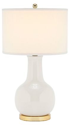 a white table lamp with a gold base