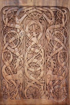 an intricate carved wood panel in the shape of a celtic letter