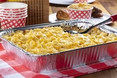 a casserole dish with macaroni and cheese in it on a red checkered tablecloth