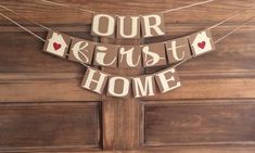 a sign that says our house is in the middle of some wood letters hanging from a clothes line