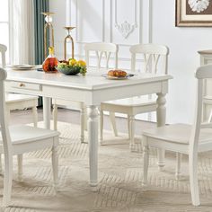 a white dining table and chairs in a room with rugs on the carpeted floor