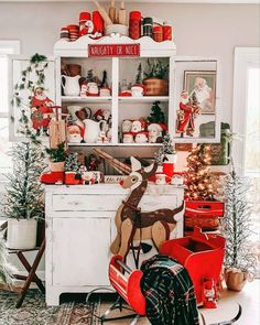 a christmas display in the corner of a living room with red and white decorations on it