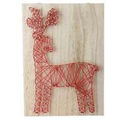 a red string art deer on a wooden surface with wood planks in the background