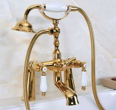 a gold faucet in the middle of a bathtub