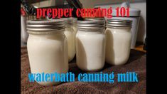 three jars filled with white liquid sitting on top of a towel