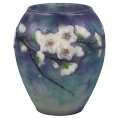 a blue vase with white flowers painted on it