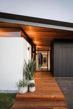 a modern house with wooden steps leading to the front door