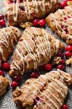 cranberry scones with white icing on a platter surrounded by cherries