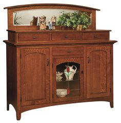 a wooden cabinet with two vases on top of it and a mirror above the door