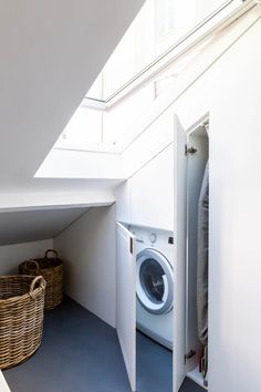 a washer and dryer in a small space under a slanted roof window