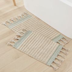 a bath tub sitting next to a rug on top of a wooden floor