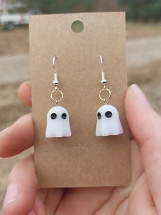 a pair of white ghost earrings with black eyes