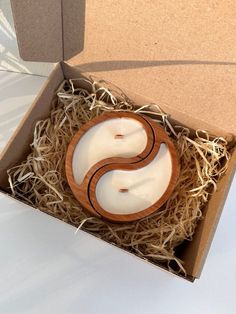 an open box with two white candles in it