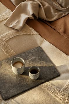 A close-up of a bed dressed in beige duvet covers in washed linen and a white bedthrow. On the bed, there’s a marble serving board with two cups of coffee. How To Wash Throw Pillows, Pergola Metal, Autumn Interior, Natural Ceramic, H&m Home, Linen Cushion, Soft Blankets, Bed Decor, Home Decor Furniture