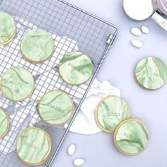 cookies with green icing on a cooling rack next to baking utensils and powdered sugar