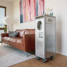 a living room with a couch and a metal cabinet in the corner next to a window