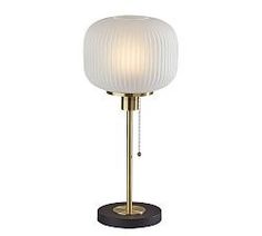 a lamp that is on top of a wooden base and has a white glass shade