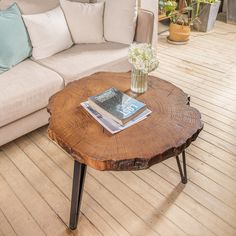 a wooden table sitting on top of a hard wood floor next to a white couch