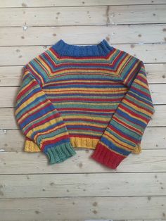 a multicolored sweater on a wooden surface