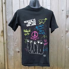 "Original vintage NEW KIDS ON THE BLOCK 1989 rare \"Backstage Pass\" promo shirt!  The dual sided neon print is still in excellent shape as shown and the material looks lightly or never worn! Single stitched. Lots of fun on this shirt - if you were a NKOTB fan then you know this shirt has it all! Size S-M Adult Made in Canada 100% Cotton   Condition: Great vintage shape. No flaws! Measures laying flat: 19 inches armpit to armpit 28 inches back of neck hem to seat hem" 90s Black Tops With Graffiti Print, 90s Black Top With Graffiti Print, 90s Style Black Top With Graffiti Print, 90s Black T-shirt With Graffiti Print, Nkotb Concert, 90s Denim Jacket, Pink Satin Dress, Neon Shirts, Neon Printing