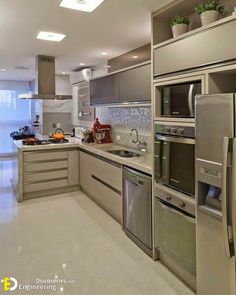 a modern kitchen with stainless steel appliances and marble counter tops, along with white tile flooring