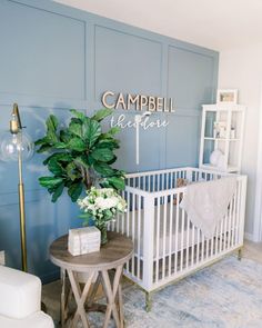 a baby's room with a white crib and blue walls