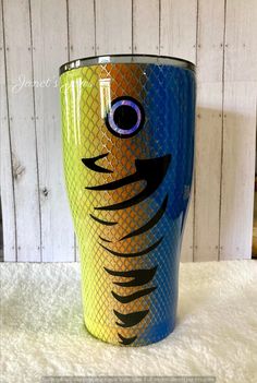 a blue and yellow cup with an image of a fish on it's side