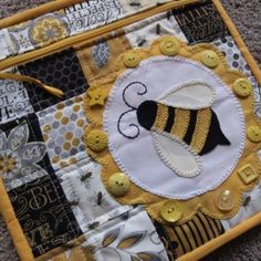 a close up of a patchwork piece with a bee on it's side