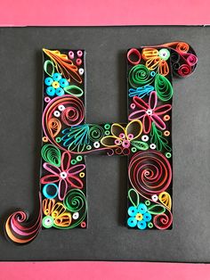 the letter h is made out of paper and decorated with colorful flowers, butterflies, and swirls