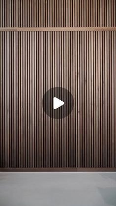 a video player is playing on the wall with wood slats in the back ground