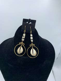 Dangle earrings with cow bone, cowrie shells, and brass. These earrings are light and measure 3.5 inches. Metal Beaded Earrings For Beach, Beach Beaded Metal Earrings, White Brass Earrings For Beach, White Brass Earrings For The Beach, Metal Beaded Drop Earrings For Beach, Beaded Metal Drop Earrings For Beach, Gold Cowrie Shell Earrings, Cow Bones, Cowrie Shells