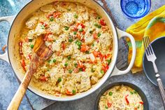 a pot filled with chicken and rice next to two bowls full of food on the table