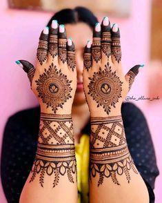 a woman's hands with henna tattoos on them