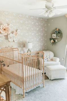 a baby's room with white furniture and flowers on the wall