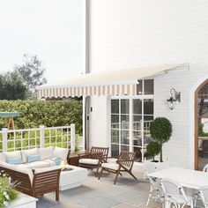 a patio with white furniture and an awning