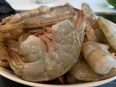 a white bowl filled with shrimp on top of a table