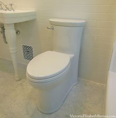 a white toilet sitting next to a sink in a bathroom