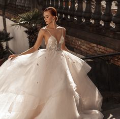 a woman in a wedding dress walking down some stairs