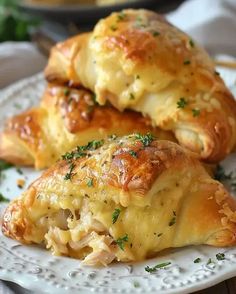 two cheesy pastries on a white plate with parsley sprinkled