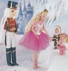 two dolls dressed as nutcrackers and a doll in a pink tutu