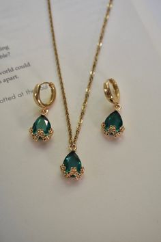 Our Emerald Night Set includes a pair of earrings and a matching necklace. This set can also be sold separately. Color - Green & Gold Material - Stainless Steel & Zinc Alloy measurements - Hoop: 0.5 inches, Earring Drop: 1.20 inches, Necklace Length: 20.5 inches. Green Gifts Aesthetic, Emerald And Gold Jewelry Set, Emerald Jewelry Gold, Emerald Jewellery Set, Emerald And Gold Necklace, Emerald Sets Jewellery, Deep Winter Jewelry, Gold Emerald Jewelry, Emerald Jewelry Aesthetic