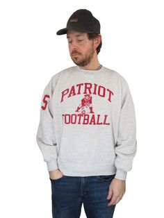 a man wearing a sweatshirt with the word's football printed on it, standing in front of a white background